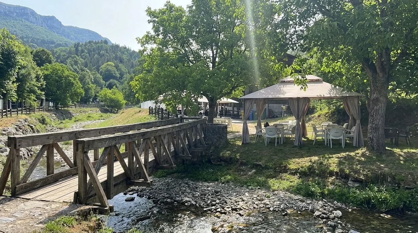 Puente de madera peatonal sobre el río Gardalar, acceso al camping