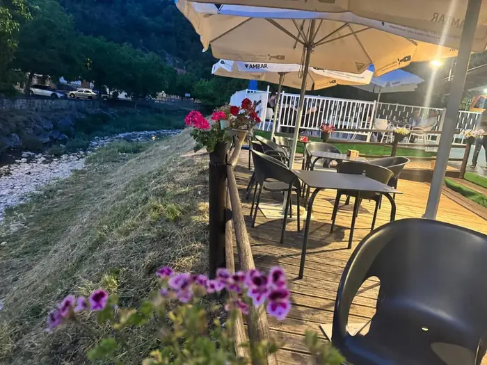 Terraza de madera del camping junto al río Gardalar con flores